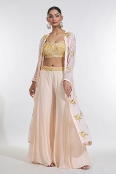 Peach full sleeves cape with sunny bloom sequin-cutdana embroidery. Paired with a sequin-cutdana chevron embroidered blouse and an embroidered waistband sharara. - Aza Fashions Fitted Front Open Palazzo Set For Diwali, Fitted Front Open Wedding Sets, Fitted Front Open Sharara With Resham Embroidery, Fitted Front Open Palazzo Set With Zari Work, Fitted Front Open Palazzo Set For Wedding, Festive Fitted Front-open Sharara, Fitted Front Open Sharara For Designer Wear, Fitted Front Open Palazzo Set, Cape Sharara