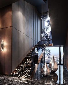 an elegant staircase leading up to the top floor in a modern building with marble floors and black walls