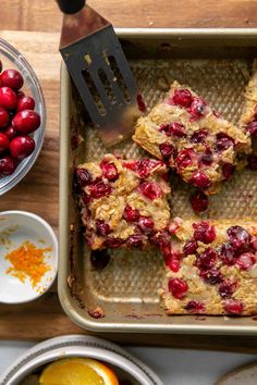 cranberry orange oatmeal bars in a baking pan with fresh fruit