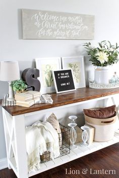 a white shelf with pictures and other items on it, along with a sign that says welcome to our home