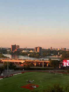 a soccer field with the city in the background