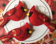 three red birds sitting on top of a white plate