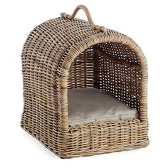 a wicker dog bed with a cushion in the front and side panels on the back