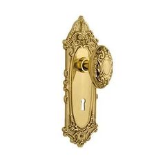 an ornate brass door handle on a white background