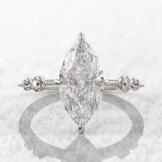 an oval cut diamond ring with three small diamonds on the band and side stones around it