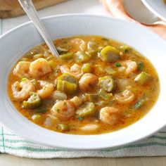 a white bowl filled with shrimp and vegetable soup