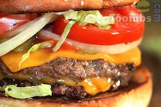 a cheeseburger with lettuce, tomato and onion