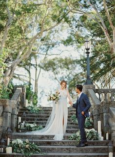 a bride and groom are standing on the stairs