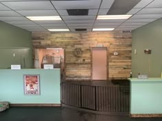 the front desk of an office building with wood paneling on the walls and metal railings