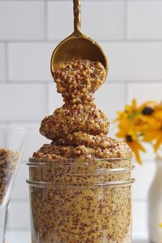 a jar filled with food sitting on top of a table next to a vase full of flowers