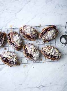 several pastries on a cooling rack with powdered sugar