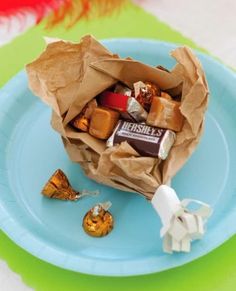 a paper bag filled with candy sitting on top of a blue plate