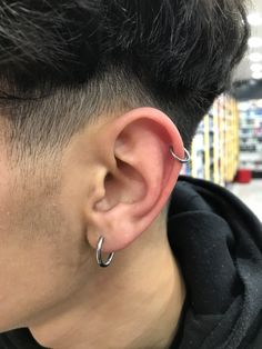 a close up of a person with ear piercings on their ears in a store