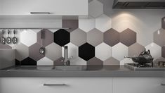 a modern kitchen with black and white hexagonal tiles on the wall behind the sink