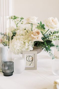 the table is set with white flowers and candles