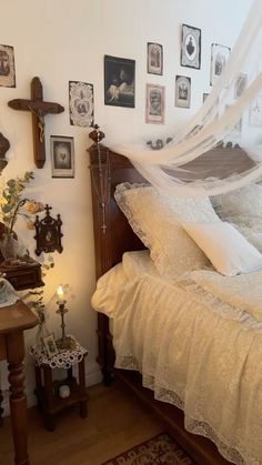 there is a bed with white sheets on it and pictures above the bedspread