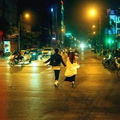 two people walking down the street at night