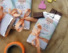 some candy bars wrapped in brown paper and tied with orange ribbon on top of a table