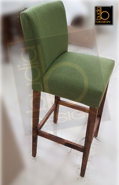 a green upholstered bar stool with wooden legs