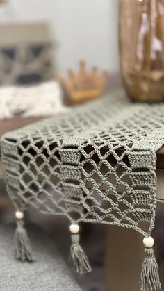 a crocheted bench with tassels on it