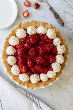 a pie topped with strawberries on top of a table