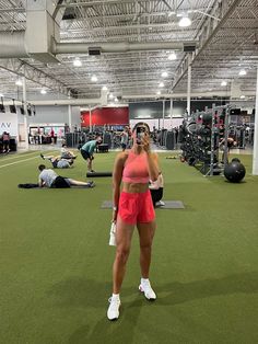 a woman standing in the middle of a gym