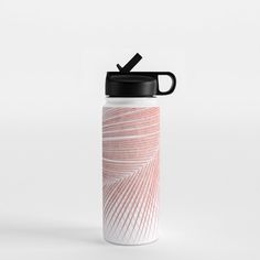 a white and pink water bottle with a black lid sitting on top of a table