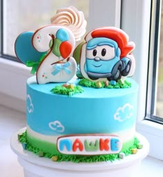 a blue cake decorated with cartoon characters on it