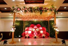 an elaborately decorated stage set up for a wedding ceremony with red and white flowers