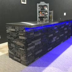 a black stone bar with blue lights on it's counter top in a room