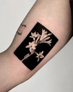 a black and white photo with flowers on it's arm, in the shape of a square