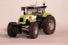 a lego model of a tractor with people standing on the front and rear wheels,