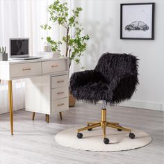 a black chair sitting on top of a wooden floor next to a white desk and drawers