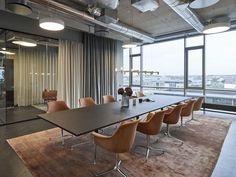 a conference room with chairs and a table in front of large windows overlooking the city