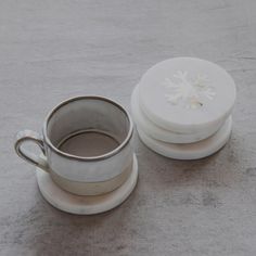 a cup and saucer sitting next to each other on top of a gray surface