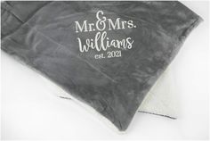 a personalized blanket with the name and date on it, sitting on top of a white surface