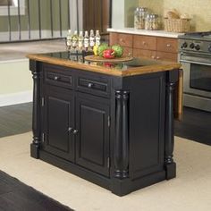 a kitchen island with two wine glasses on it and an assortment of fruit in the middle