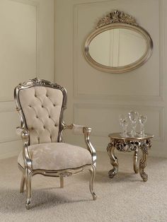 a chair and table in a room with a mirror on the wall behind it,