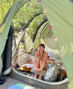 a woman sitting in a tent on the ground