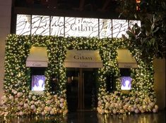 the entrance to gulian's is decorated with flowers and greenery for christmas