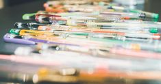 many different colored pens lined up on a table