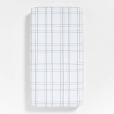 the white and blue plaid sheet set is folded on top of a plain wallpaper