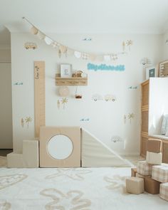 a room with toys and decorations on the wall, including a cardboard box in front of it