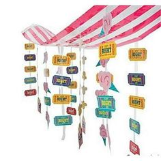 a pink and white striped tent with signs hanging from it