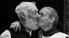 an old man and woman kissing each other