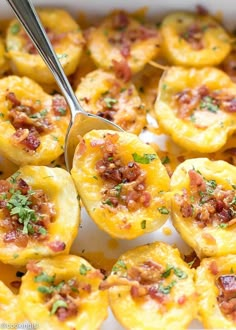 bacon and cheese stuffed potatoes in a casserole dish with a spoon resting on top