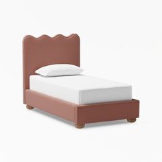 a bed with a pink headboard and white sheets on it's bottom half