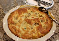 a baked dish on a plate with a spoon