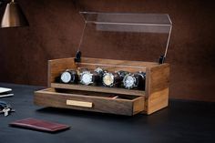 a wooden watch display case sitting on top of a table