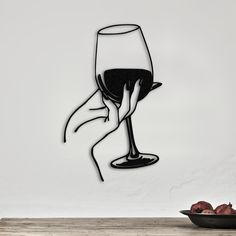 a drawing of a hand holding a wine glass in front of a bowl of fruit